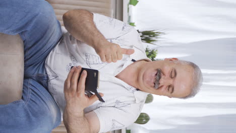 Vertical-video-of-Happy-and-happy-texting-old-man.